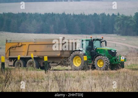 John Deere 6215R-Traktor mit einem gelben 12-Tonnen-Kippanhänger Stockfoto