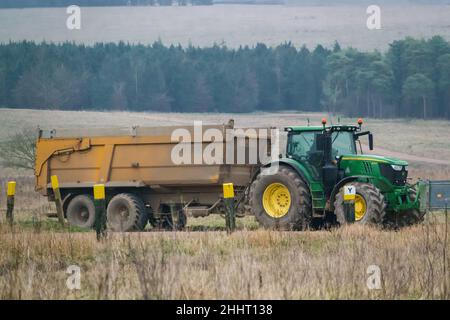 John Deere 6215R-Traktor mit einem gelben 12-Tonnen-Kippanhänger Stockfoto