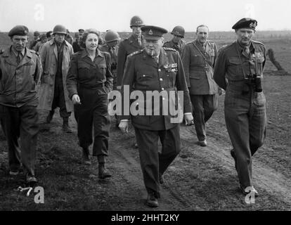 Winston Churchill und Bernard Montgomery überqueren den Rhein.am 25th. März überquerte Churchill mit Feldmarschall Montgomery in einem amerikanischen L.C.U.P. das Ostufer des Rheins Das Bild zeigt: Der Premierminister und Feldmarschall Montgomery, der am East Bank entlang läuft. Neben ihnen iss Rhona Churchill, akkreditierte Korrespondentin von I.N.A., die als erste Britin den Rhein überquert hat. Ihre Artikel erscheinen in der Daily Mail. 26th. März 1945. Stockfoto