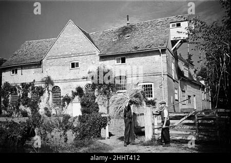 Zwei Männer arbeiten in Flatford Mill, am Fluss Stour in der Nähe der Grenze zwischen Suffolk und Essex. Die Mühle ist in vielen Gemälden von John Constable zu sehen. East Bergholt, Suffolk. Ca. 1945. Stockfoto