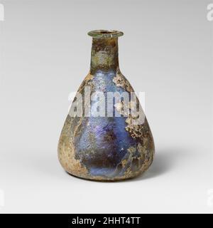 Parfümflasche aus Glas 1st. Jahrhundert n. Chr. römisch farblos mit blassblaugrüner Färbung.Rand ausgeklappt, über und in, oben abgeflacht; kurz, Zylindrischer Hals, mit Werkzeugmarkierungen um die Basis; konischer Körper, an der Basis abgerundet; konkav bottom.Complete, aber gebrochen und auf einer Seite des Randes repariert; viele Nadelstichtblasen; tiefes Lochfraß, Abstumpfen und schillernde Verwitterung.enthält großes Schwarz (verbrannt ?) Volumenkörper... Parfümflasche aus Glas 244589 Stockfoto