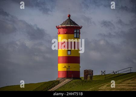 Der gelbe und rote Leuchtturm von Pilsum in der Morgensonne (Fokus auf den Leuchtturm) Stockfoto