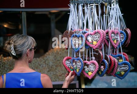 Eine junge Frau mit Herz formte traditionelle deutsche Lebkuchen-Lebkuchen, die vor einem Laden in der Frankfurter Innenstadt hingen Stockfoto