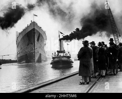 Die Markteinführung des Luxus-Ozeandampfers Cunard Line RMS Queen Elizabeth auf der John Brown Werft am Fluss Clyde, der vom Schlepper des Flying Eagle gezogen wird 27th. September 1938. Stockfoto