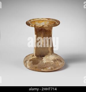 Parfümflasche aus Glas ca. 2nd. Jahrhundert n. Chr. Römisches Unguentarium vom Typ Spindel. Farblos mit gelber Färbung. Tubular-Rand ausgeklappt, über und in und gepresst in breiten, abfackelnden Mund; zylindrischer Hals, leicht nach unten ausdehnend; sehr hockiger Körper mit abgerundeten abfallenden Seiten; unebener Boden mit konkavem Zentrum. Intakt; Nadelstich und längliche Blasen; stumpf, Lochfraß, schwache Irideszenz und cremige Verwitterung. Parfümflasche aus Glas 244649 Stockfoto