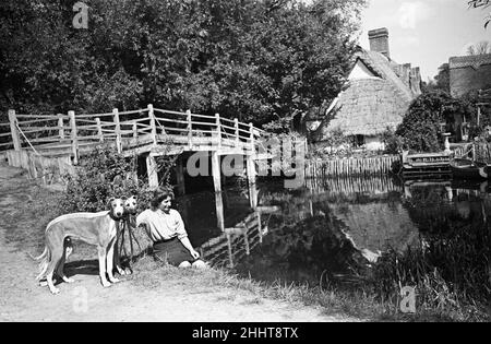 Eine Frau mit zwei Hunden in Flatford Mill, am Fluss Stour in der Nähe der Grenze zwischen Suffolk und Essex. Die Mühle ist in vielen Gemälden von John Constable zu sehen. East Bergholt, Suffolk. Ca. 1945. Stockfoto