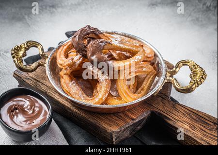 Churros con chocolate typisch spanischer süßer Snack in einer Pfanne. Grauer Hintergrund. Draufsicht Stockfoto