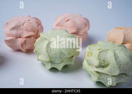 Köstliche süße Süssmarmelibe auf weißem Hintergrund, farbige Süssmarmelibe zum Nachtisch. Ein luftiger Marschmalg in Pastellfarben. Nahaufnahme Stockfoto