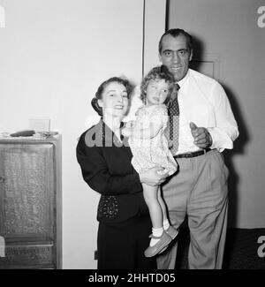 Primo Carnera, Wrestler, ehemaliger Boxer, mit Peggy Brindle und ihrer Tochter Susan aus New York, USA. Er hat Susans medizinische Behandlung in Großbritannien finanziert, sie wurde früh und blind geboren und konnte in Amerika nicht unterstützt werden. Frau Brinde schickte Susan vor 18 Monaten nach Großbritannien. Seitdem haben Chirurgen im Londoner Moorfield's Hospital Susan perfekten Blick in ihr linkes Auge gegeben und hoffen, das sehnlose rechte Auge zu reparieren. Auf dem Bild: Susan trifft ihren Wohltäter zum ersten Mal in seinem Hotel, Kensington, London, am 6th. September 1954. Stockfoto