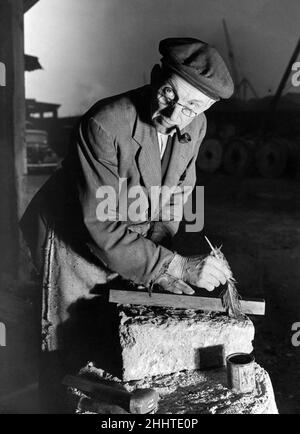 Mühlsteinherstellung, vor dem Schneiden des Schmirgelsteins wird die Linie mit einer in Farbstoff getauchten Feder markiert, 1st. Januar 1944. Stockfoto