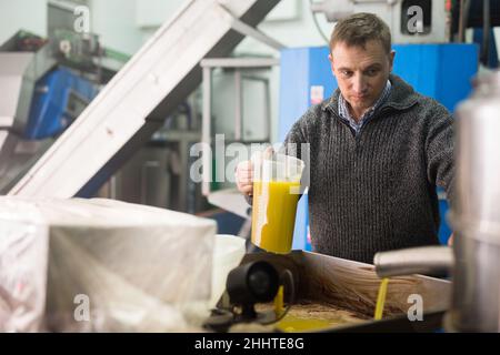 Mann, der den Prozess der Öldekantierung kontrolliert Stockfoto