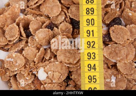 Bio-Müsli in beige Schüssel mit Klebeband messen Diät-Lebensmittel. Stockfoto