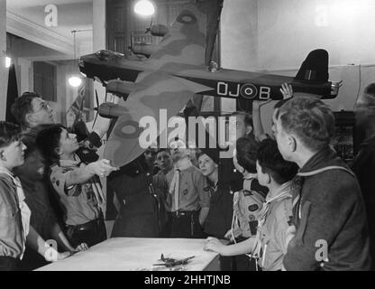 Junge Flugscouts, die sich ein Modell eines stirling-Bombers angeschaut haben und neugierig wissen möchten, woher die Bombe kommt, wenn sie abgeworfen wird, auf der Air Scout Exhibition im Dorland Park in London. 28th. Dezember 1942. Stockfoto