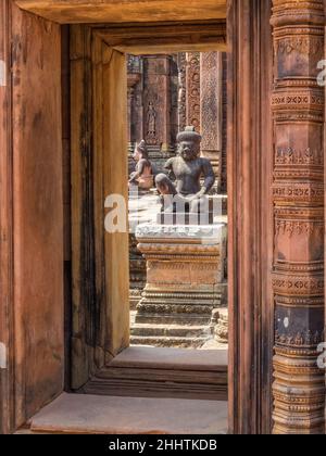 Kniende Wächter wachen über das Innere der 'Zitadelle der Frauen' - Banteay Srei, Kambodscha Stockfoto