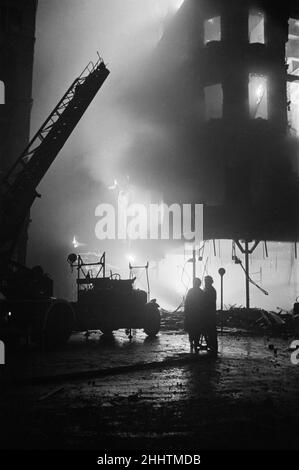 Feuerwehrleute des Hilfsfeuerwehrdienstes besuchen die Szene des flammenden Gebäudes 50 Shilling Tailors in Swallow Street, Piccadilly, Central London, nachdem es am Abend des 14th. Oktober 1940 von einer Brandbombe getroffen wurde, die von der deutschen Luftwaffe bei einem Angriff auf London abgeworfen wurde. Stockfoto