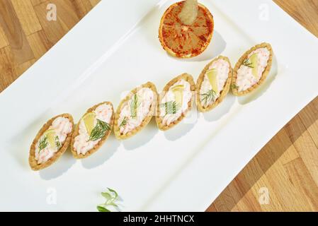 Salat mit Rogen, gewürzt mit Tomaten und Zitrone Stockfoto