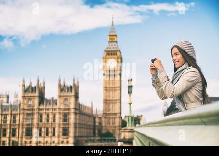 Reise-Tourist in london Sightseeing Fotografieren in der Nähe von Big Ben. Frau mit Smartphone-Kamera lächelnd in der Nähe des Palastes von Westminster Stockfoto