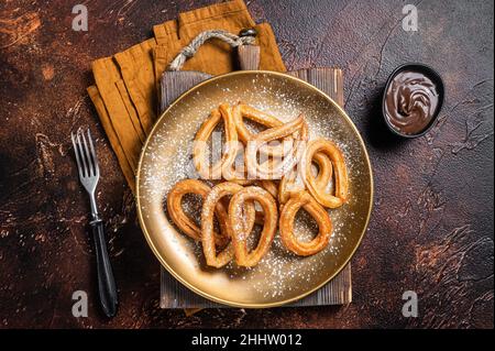 Spanische Dessert-Churros mit scharf würziger Schokolade. Dunkler Hintergrund. Draufsicht Stockfoto