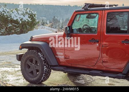 Wrangler Sport Jeep Parkplatz im Winter Park in Kanada. Nahaufnahme eines roten Jeeps am Wintertag Stockfoto