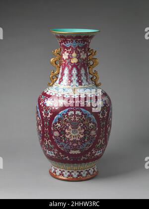 Vase mit floralen Medaillons Mitte des 18th. Jahrhunderts China die floralen Schriftrollen in Kunstwerken der Qing-Dynastie, einschließlich der zart eingeschnittenen Designs, die die karmesinrote Oberfläche dieser Vase sowie die kühneren weißen Blüten darüber füllen, wurden höchstwahrscheinlich von Mustern inspiriert, die in Textilien gefunden wurden. Die vier floralen Rundungen in der Mitte deuten auch auf den Einfluss textiler Designs hin. Vase mit floralen Medaillons 46083 Stockfoto