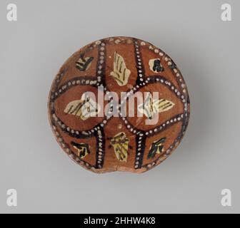 Schale mit Polychromdeko auf rotem Rutschboden 9th Jahrhundert Schalen aus Slips (verdünnter Ton) mit vollständig lokalen Designs wurden in der Umgebung von Nishapur hergestellt. Diese Rutschwaren unterscheiden sich leicht von den Keramiken, die im Rest des abbasidischen Reiches, zu dem Nishapur gehörte, hergestellt wurden, und stehen in keinem Verhältnis zu den populären chinesischen Keramiken, die auch in Nishapur hergestellt wurden. Diese Schale kombiniert eine der bevorzugten Paletten – ein bräunliches Rot, verziert mit Schwarz und Weiß – und die typischen Motive dieser Art: Ein Strapwork, das abstrakte florale Designs umschließt. Kleine Schüsseln wie diese wir Stockfoto
