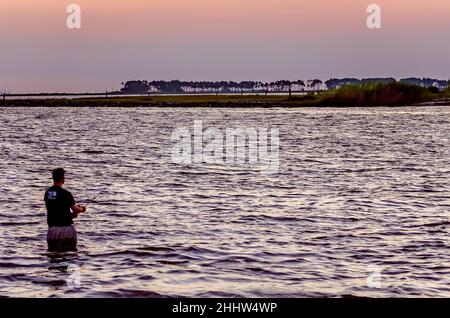 Ein Mann steht im hüfttiefen Wasser beim Angeln, 29. August 2013, in Bayou La Batre, Alabama. Die Stadt ist bekannt als die Meeresfrüchtetropole von Alabama. Stockfoto