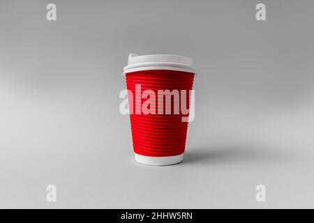 Einweg-Becher aus rotem Papier für Kaffee auf grauem Hintergrund. Stockfoto