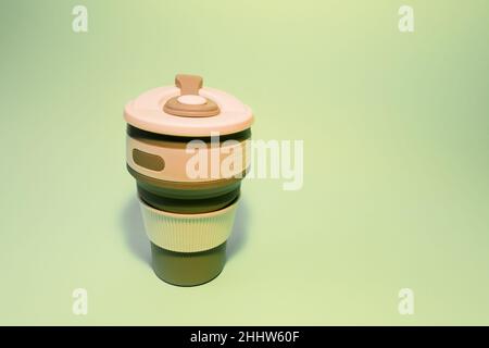 Wiederverwendbare Silikonbecher für Kaffee auf hellem Hintergrund. Stockfoto