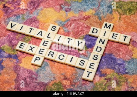 Vitalität, Denkweise, Bewegung, Ernährung und Schlaf Kreuzworträtsel in Elfenbein Buchstaben Fliesen gegen strukturierte handgemachte Papier, gesunde Lebensweise Konzept Stockfoto