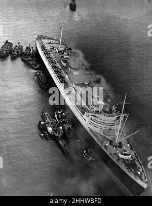 RMS Queen Elizabeth, Ozeandampfer der Cunard Line. Im Februar 1940 trat sie erstmals als Truppenschiff im Zweiten Weltkrieg in Dienst, und erst im Oktober 1946 diente sie in ihrer beabsichtigten Rolle als Ozeandampfer. Abgebildet. RMS Queen Elizabeth Aground in Southampton Waters, 15th. April 1947. Stockfoto