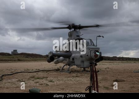 Ein AH-1W Super Cobra-Hubschrauber vom Marine Medium Tiltrotor Squadron (VMM) 265 (rein.), 31st Marine Expeditionary Unit (MEU) erhält während einer Vorwärts-Aufrüst- und Betankungspunktübung auf der IE Shima Island, in Okinawa, Japan, am 6th 2022. Januar Treibstoff. Die Marineinfanteristen führten eine sogenannte Heißladung durch, betanken und verladen, während der Hubschrauber noch unter Strom steht. Die 31st MEU, die einzige kontinuierlich im Vorwärtslauf eingesetzte MEU des Marine Corps, stellt eine flexible und tödliche Truppe bereit, die als erste Krisenreaktionstruppe im Indo-Pazifik-Raum eine breite Palette von Militäroperationen durchführen kann Stockfoto