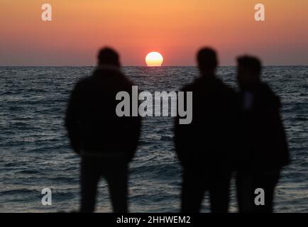 Gaza, Palästina. 25th Januar 2022. Palästinenser genießen die Küste bei Sonnenuntergang im Westen von Gaza City. Kredit: SOPA Images Limited/Alamy Live Nachrichten Stockfoto