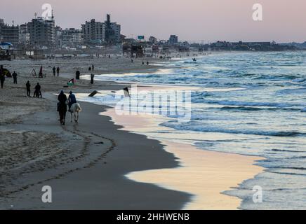 Gaza, Palästina. 25th Januar 2022. Palästinenser genießen die Küste bei Sonnenuntergang im Westen von Gaza City. Kredit: SOPA Images Limited/Alamy Live Nachrichten Stockfoto