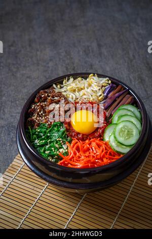 Bibimbap Reisgericht im koreanischen Stil. Schüssel mit warmem, weißem Reis mit Rindfleisch Bulgogi, Sauteed und gewürztem Gemüse gekrönt Stockfoto