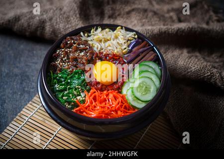 Bibimbap Reisgericht im koreanischen Stil. Schüssel mit warmem, weißem Reis mit Rindfleisch Bulgogi, Sauteed und gewürztem Gemüse gekrönt Stockfoto