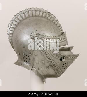 Close-Helm für das Feld ca. 1550 Westeuropäisch die Reihen der angehobenen Lappen entlang der Seiten des Kamms und der Kanten des Visiers und der oberen Kante sind höchst ungewöhnlich, ebenso der kühn gezahnte Rand des Kamms. Dieser Helm kombiniert italienische und deutsche Funktionen und trotzt der einfachen Zuordnung. (Die Halsbänder fehlen.) Close-Helm für das Feld. Westeuropäisch. Ca. 1550. Stahl. Helme Stockfoto