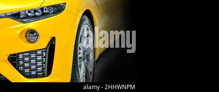 Gelbe moderne Autoscheinwerfer auf schwarzem Hintergrund, freier Platz auf der rechten Seite für Text. Stockfoto