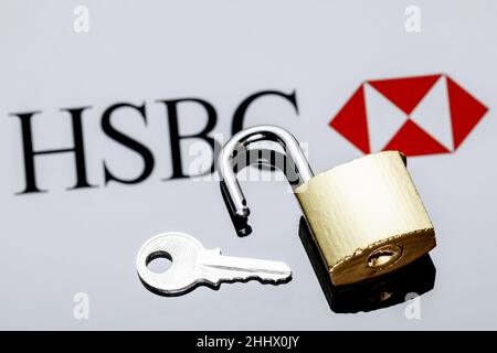 Ein offenes Sicherheitsschloss und Schlüssel auf dem Hintergrund des HSBC-Banklogos in Spiegelreflexion Stockfoto