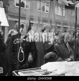 Frauen kaufen Seide und Nylonstrumpf an einem Marktstand auf einem unbenannten Straßenmarkt im East End von London ein 11th. Januar 1955 Stockfoto