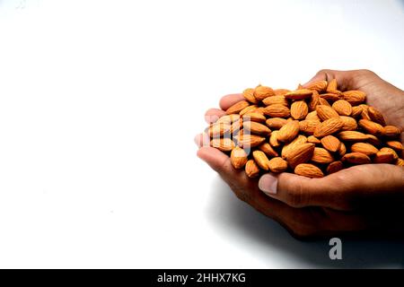 Geröstete gesalzene rohe Cashewnüsse in einer Holzschüssel auf einem rustikalen Tisch, gesunder vegetarischer Snack, Anacardium occidentale, Cashews auf weißem Hintergrund, Cashews. Stockfoto