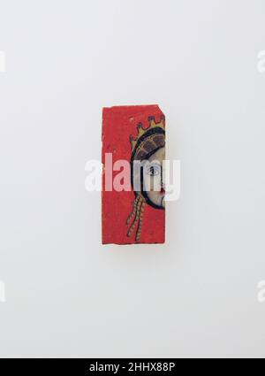 Mosaikglaseinlage 1st. Jahrhundert v. Chr.–1st. Jahrhundert n. Chr. römischer, wahrscheinlich ägyptischer opak streifenroter Boden; Dekoration in opak-weiß, gelb und rot, teilweise durchscheinend violett, schwarz und hellblau, und farbloses Glas. Dünne, rechteckige Plakette, geschnitten aus einem Mosaik-Verbundbalken, mit flacher Front, unebenem Rücken und vertikalen geraden Seiten, mit scharfen Ecken; Das Design erstreckt sich gleichmäßig über die Dicke der Plaque. Richtige rechte Seite des weiblichen Kopfes mit weißem Gesicht, in Purpur umrandet; in Blau umrandet, mit roten Lippen; Haare in Reihen von lila Haarsträhnen, gelb umrandet, mit thr Stockfoto