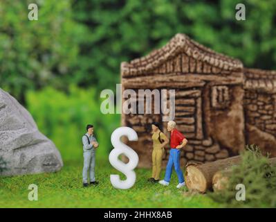 Miniaturmenschen mit weißem Absatzsymbol vor einem Haus, Rechte und Pflichten zwischen Käufer und Verkäufer Stockfoto
