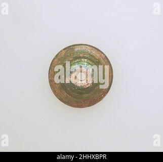 Glas-Spindel-Whorl ca. 1st–2nd. Jahrhundert n. Chr. römisch lichtdurchlässig hellgrün.hoher, gewölbter Körper; leicht konvexer Boden; senkrechtes Loch unten etwas größer.Spiralrippen auf der Ober- und Unterseite. Intakt; Nadelstich Blasen; Lochfraß und cremig schillernde Verwitterung.. Spindelwelle aus Glas Roman. Ca. 1st–2nd Jahrhundert n. Chr. Glas; stabförmig und gewickelt. Früh bis mittelkaiserlich. Glas Stockfoto