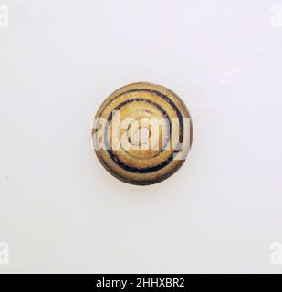 Glas-Spindel-Whorl ca. 1st–2nd. Jahrhundert n. Chr. Roman Durchscheinendes Kobaltblau, mit opaker weißer Spur.gewölbter Körper, in der Mitte leicht abgeflacht; flacher Boden; vertikales Loch.Pfad, der in einer Spirale von der Mitte zur äußeren Kante auf die obere Oberfläche aufgetragen wird.intakt; etwas trüb und schwache Verwitterung.hergestellt durch gewundene Spur in einer Spirale um den Stab. Spindelwelle aus Glas Roman. Ca. 1st–2nd Jahrhundert n. Chr. Glas; stabförmig und gewickelt. Früh bis mittelkaiserlich. Glas Stockfoto