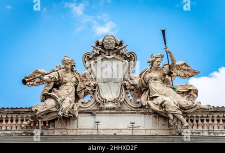 Zwei Trompetenengel, die den Ruhm repräsentieren, das Wappen der Familie Corsini auf dem Palazzo della Consulta auf dem Hügel Quirinale, Rom. Stockfoto