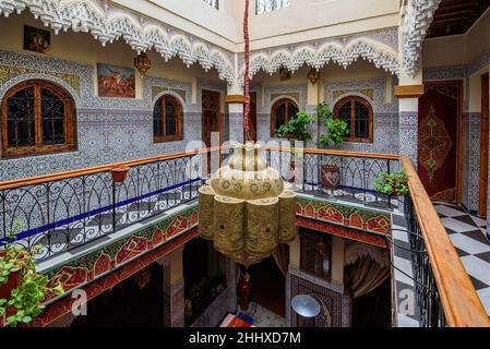 Traditionelle, reich verzierte und farbenfrohe Arabeske Wandschnitzereien über einem Torbogen im marokkanischen Riad in Marrakesch, Marokko Stockfoto