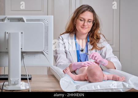 Ein Arzt in Uniform überprüft den Mund eines Kindes mit einem Spiegel. Der Zahnarzt untersucht die Zähne eines Neugeborenen Stockfoto