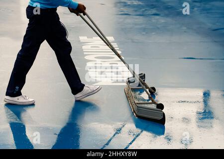 Melbourne, Australien. 26th Januar 2022. Tennis: Grand Slam - Australian Open. Ein Mann trocknet den Boden eines Gerichts im Melbourne Park. Quelle: Frank Molter/dpa/Alamy Live News Stockfoto