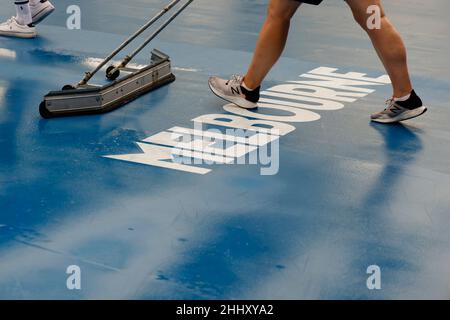 Melbourne, Australien. 26th Januar 2022. Tennis: Grand Slam - Australian Open. Eine Frau trocknet den Boden eines Gerichts im Melbourne Park. Quelle: Frank Molter/dpa/Alamy Live News Stockfoto
