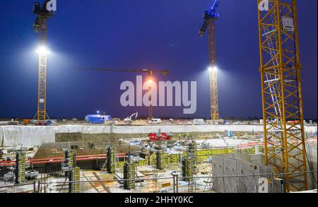 Hannover, Deutschland. 26th Januar 2022. In den frühen Morgenstunden werden im Entwicklungsgebiet Kronsrode Mehrfamilienhäuser gebaut. In einem der größten Neubaugebiete Norddeutschlands entstehen auf 53 Hektar Land im Südosten Hannovers 3.500 neue Wohneinheiten. Das Bundesministerium für Wirtschaft hatte am Montag die staatlichen Subventionen für Neubauten eingestellt, da es eine Flut von Anträgen und Milliardenzuschläge gab und massive Proteste auslöste. Quelle: Julian Stratenschulte/dpa/Alamy Live News Stockfoto